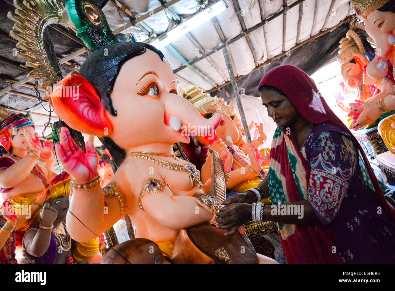 Ahmedabad, Gujarat, India, 24th Aug, 2014. :Maniben cleaning the idol on sunday morning for sale, Gulbai tekra is the single largest  supplier of Ganesha idols in Ahmedabad, Gujarat India. Credit:  Nisarg Lakhmani/Alamy Live News Stock Photo