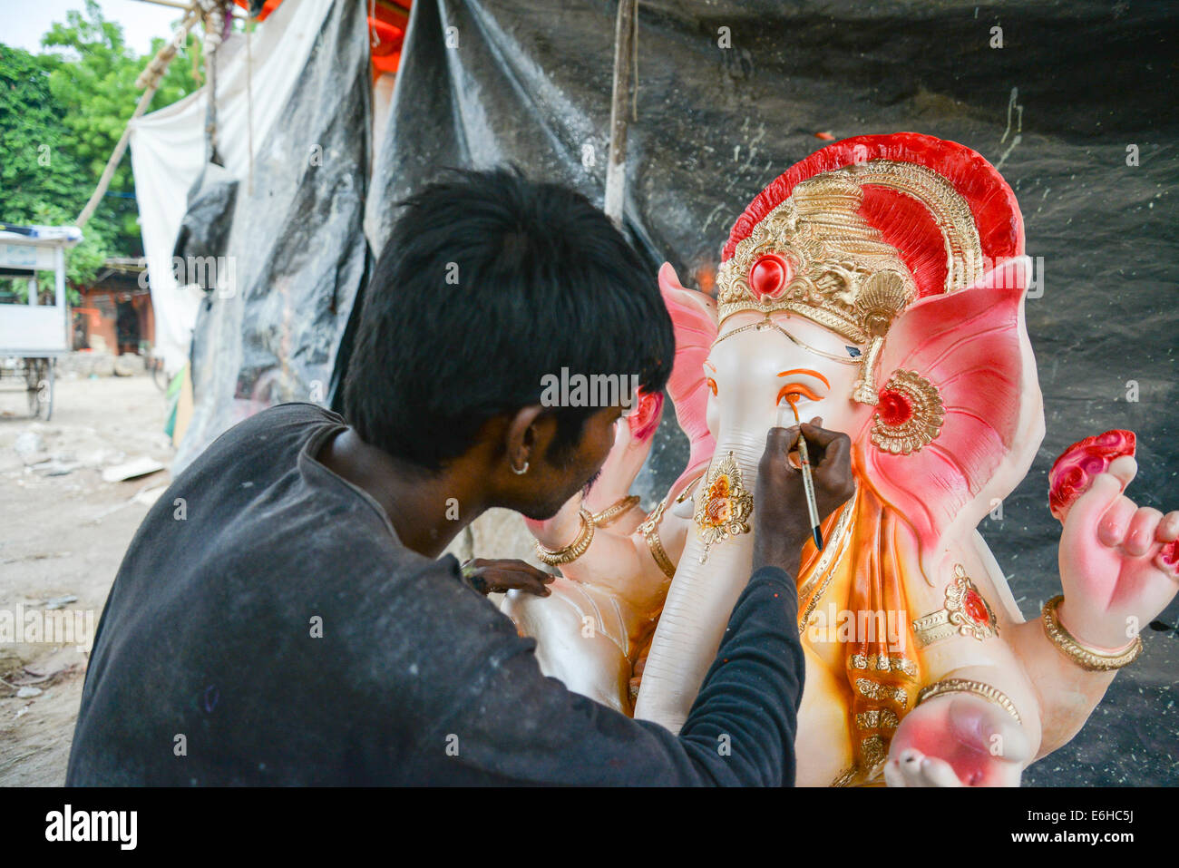 Ahmedabad, Gujarat, India, 24th Aug, 2014. :Artist working on the final touchup before sale,Gulbai tekra is the single largest supplier of Ganesha idols in Ahmedabad, Gujarat India. Credit:  Nisarg Lakhmani/Alamy Live News Stock Photo