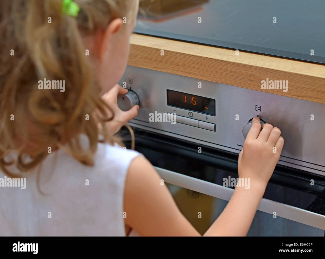 Dangerous situation in the kitchen. Child playing with electric oven