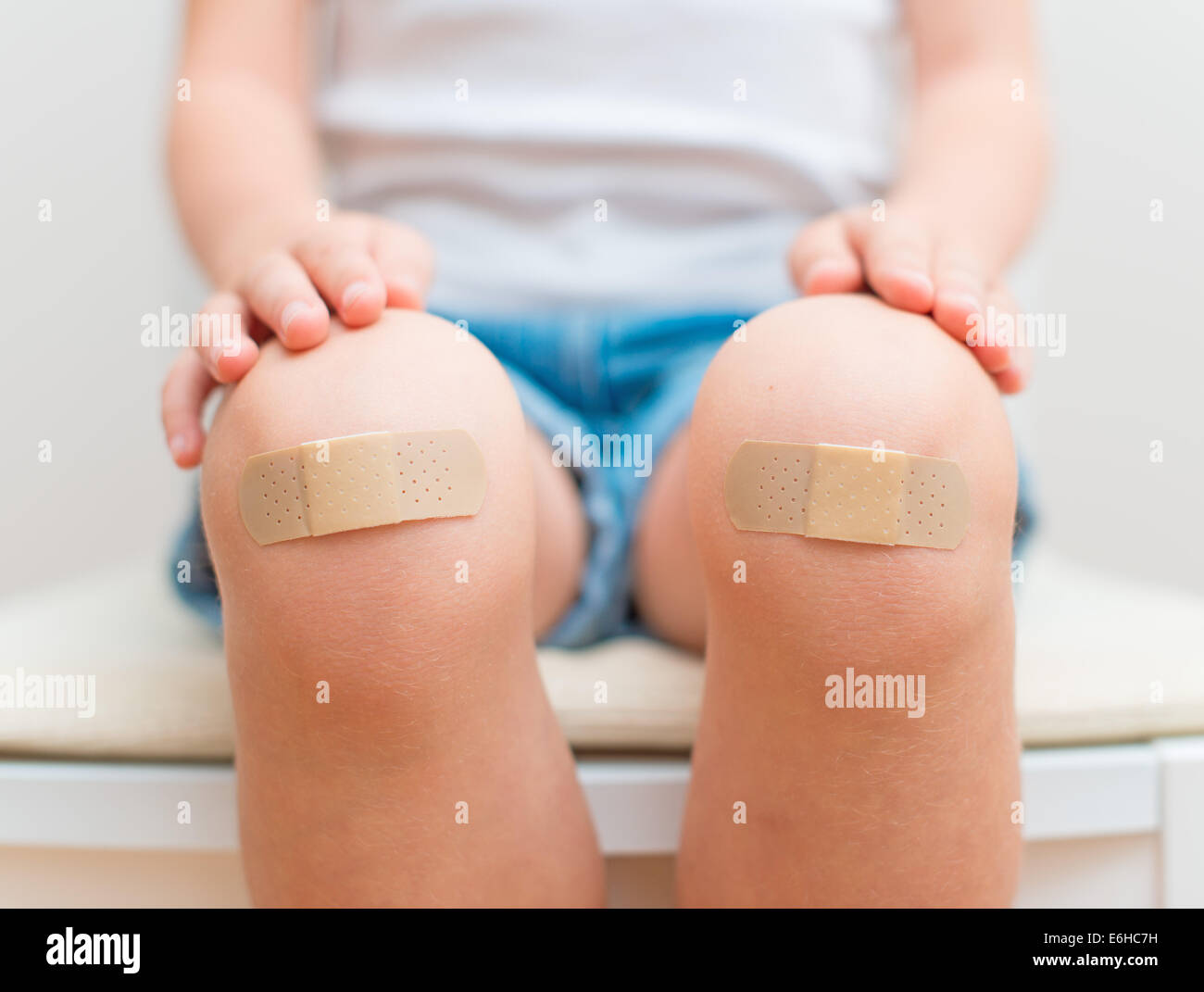 Child knee with an adhesive bandage. Stock Photo