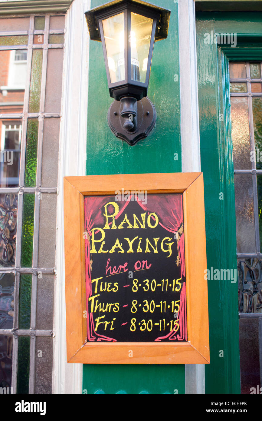 Piano playing sign on chalkboard blackboard outside pub London England UK Stock Photo