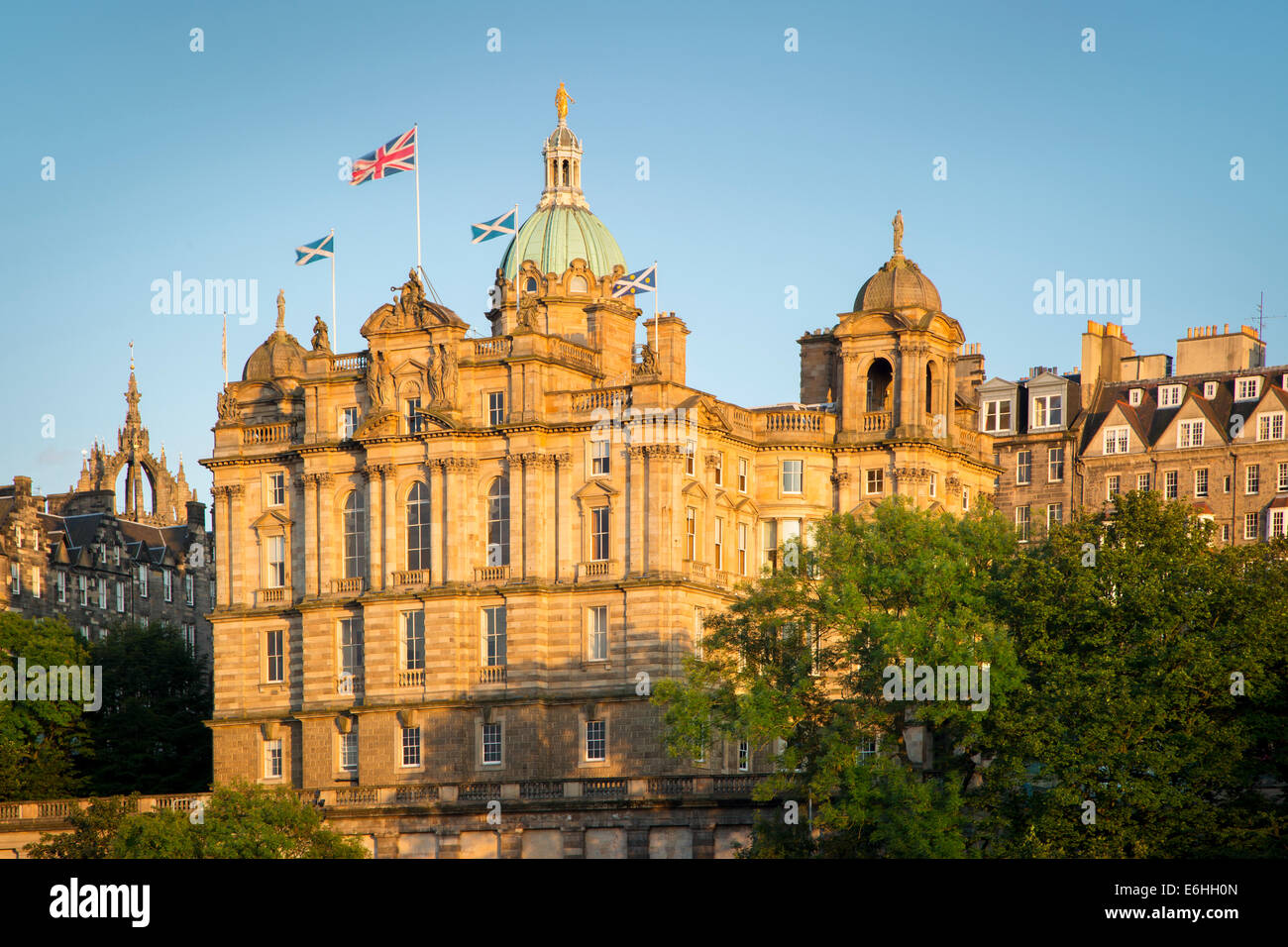 Flags fly over the Bank of Scotland building at sunset, Edinburgh, Scotland Stock Photo