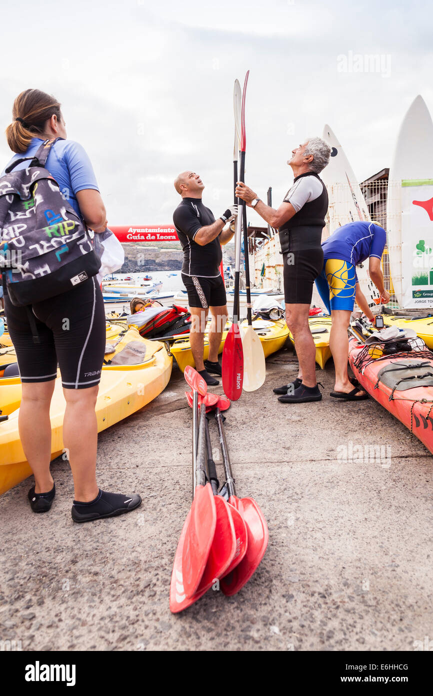 Participants getting their oars ready for a kayak race from Playa San Juan in Tenerife, Canary Islands, Spain Stock Photo