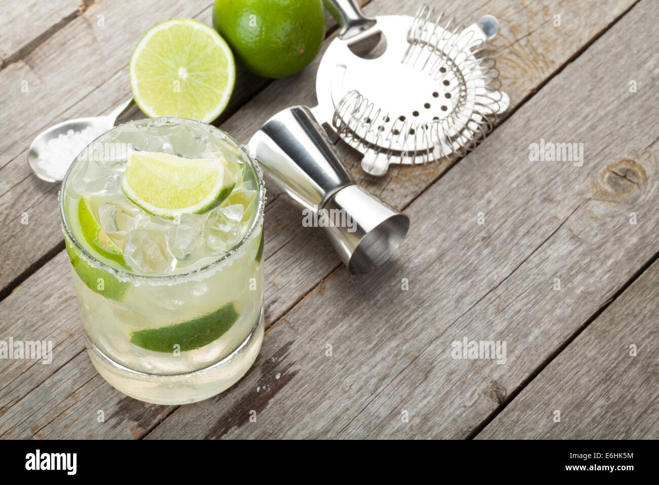 Classic margarita cocktail with salty rim on wooden table with limes ...