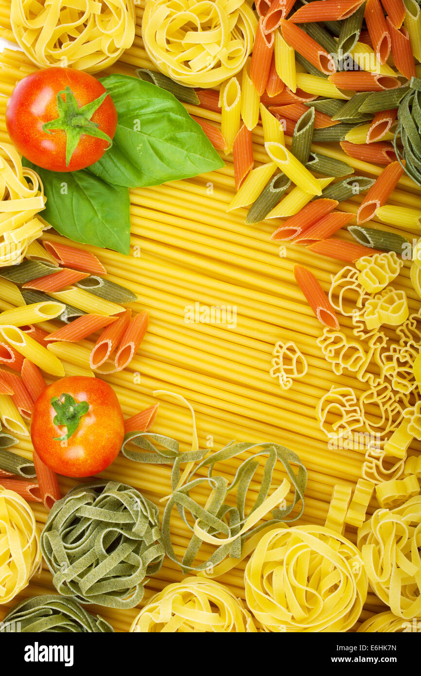 Various Italian pasta background with tomatoes and basil Stock Photo ...