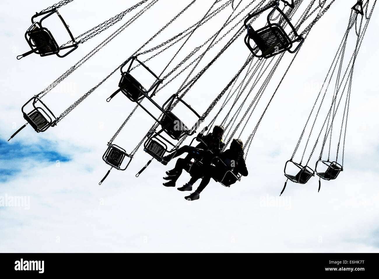 The silhouette of children on a fairground ride. Stock Photo