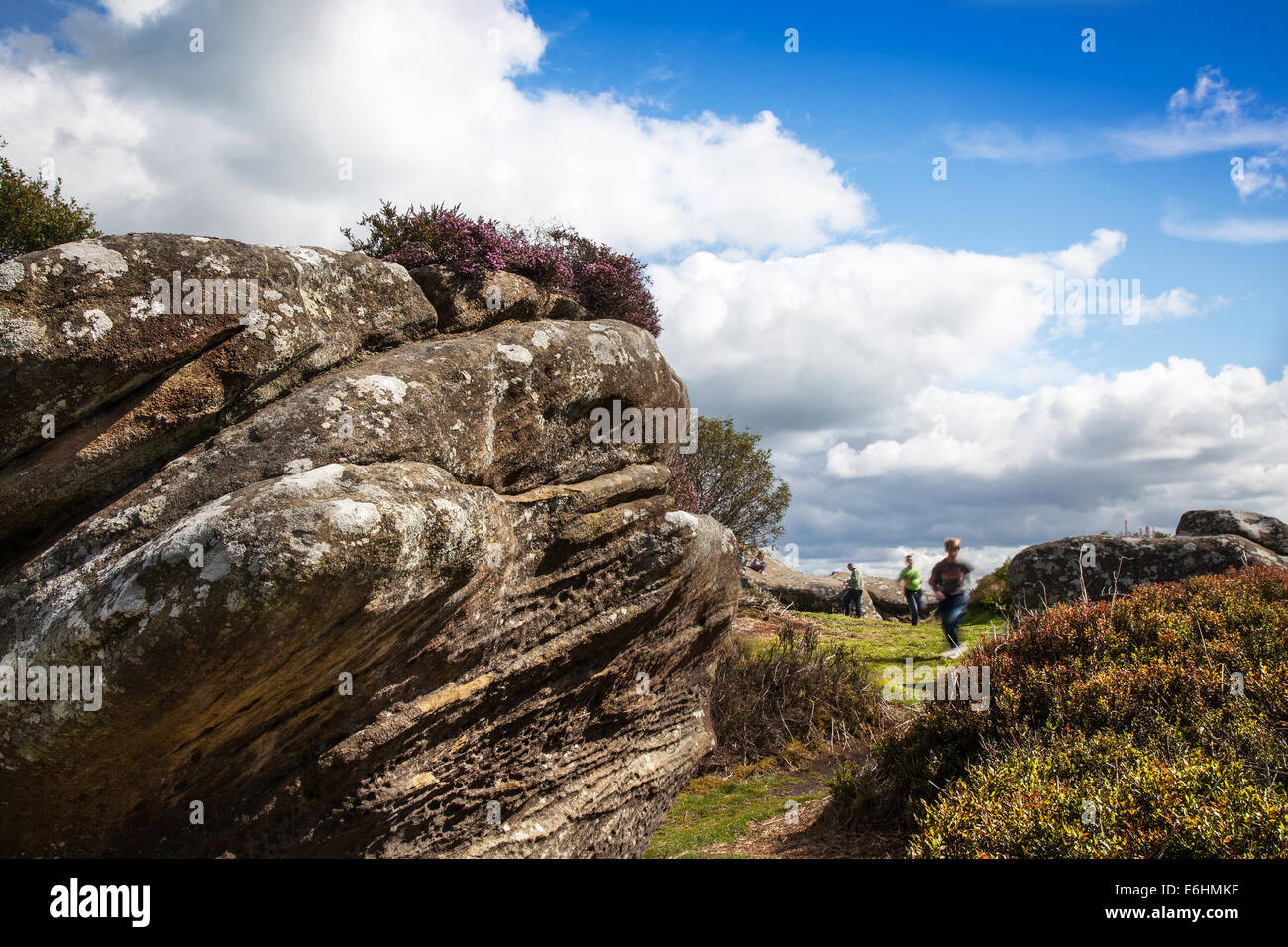 People at Brimham Rocks; Brimham Crags a collection of balancing natural rock formations sculpted over centuries by ice, wind and rain in the North Yorkshire Dales. holidaying active kids and visiting tourists at the National Trust Site making a great day out for families and climbers enjoying  a peculiar set of rock formations composed of millstone grit shaped by wind and weather Stock Photo
