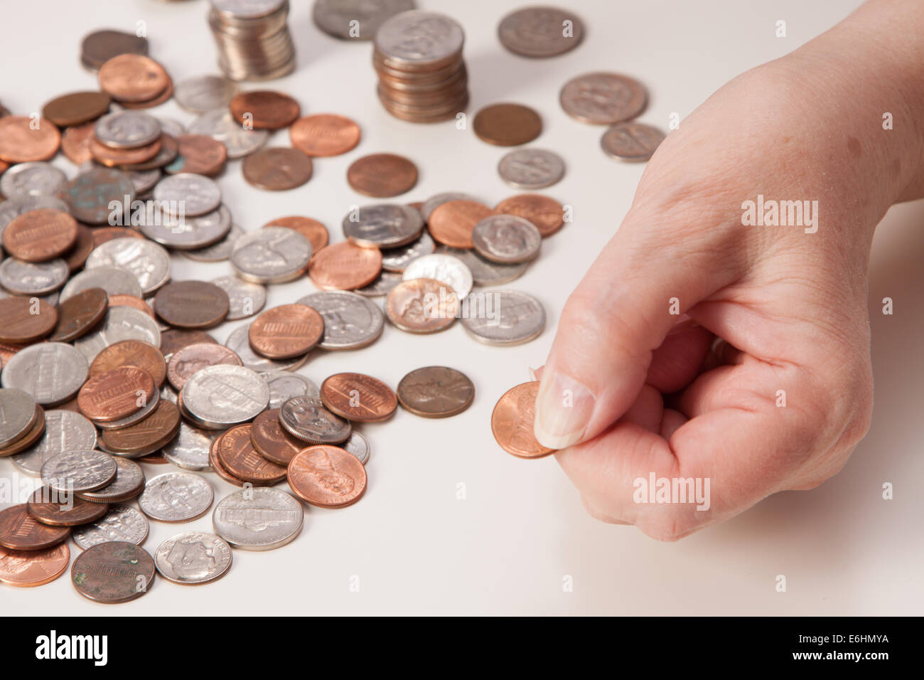 Woman's hand close up pinching a penny. Concept of retirement and not