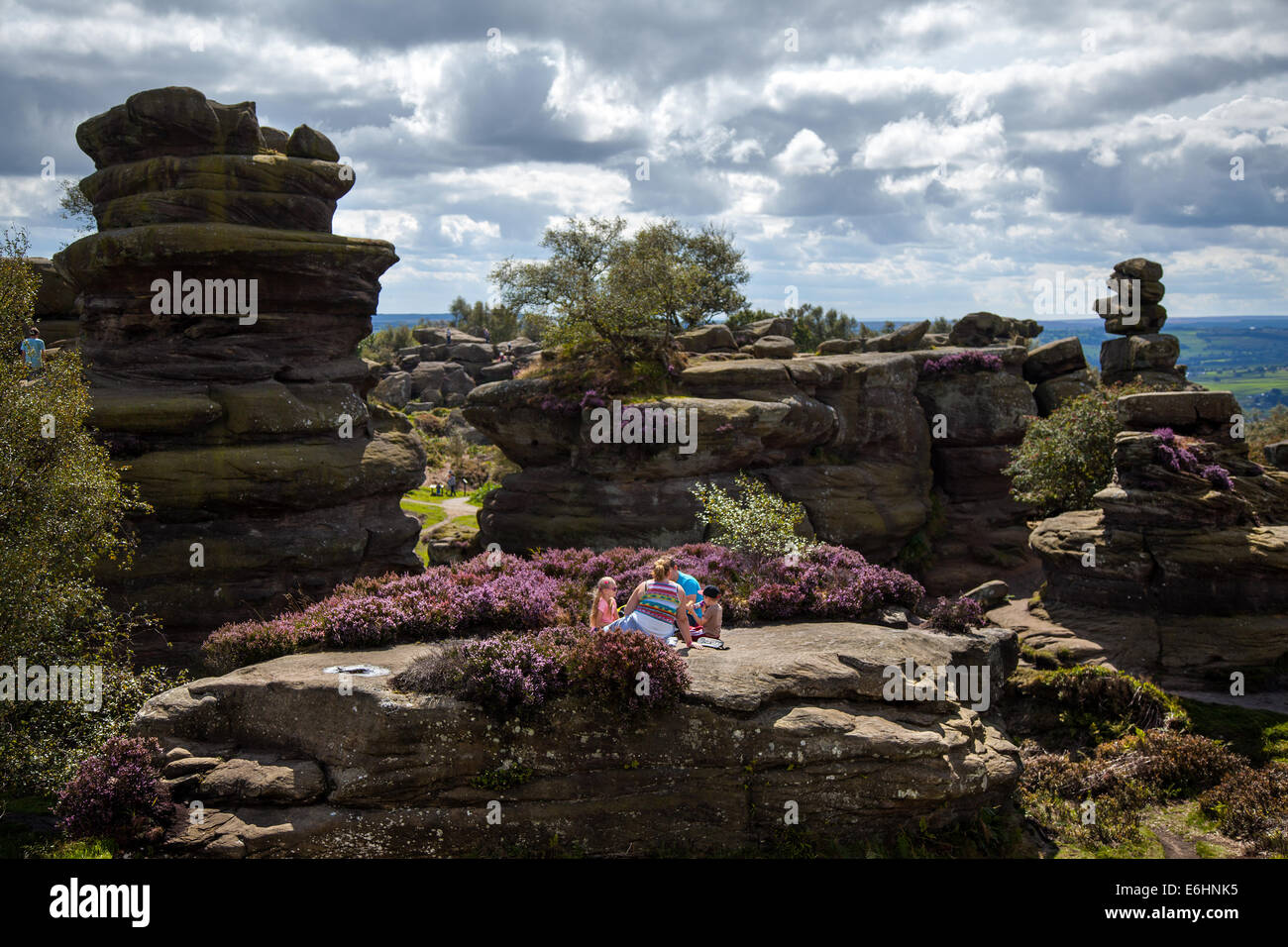 People at Brimham Rocks; Brimham Crags Harrogate is a collection of balancing natural rock formations sculpted over centuries by ice, wind and rain in the North Yorkshire Dales. holidaying active kids and visiting tourists at the National Trust Site making a great day out for families and climbers enjoying  a peculiar set of rock formations composed of millstone grit shaped by wind and weather Stock Photo