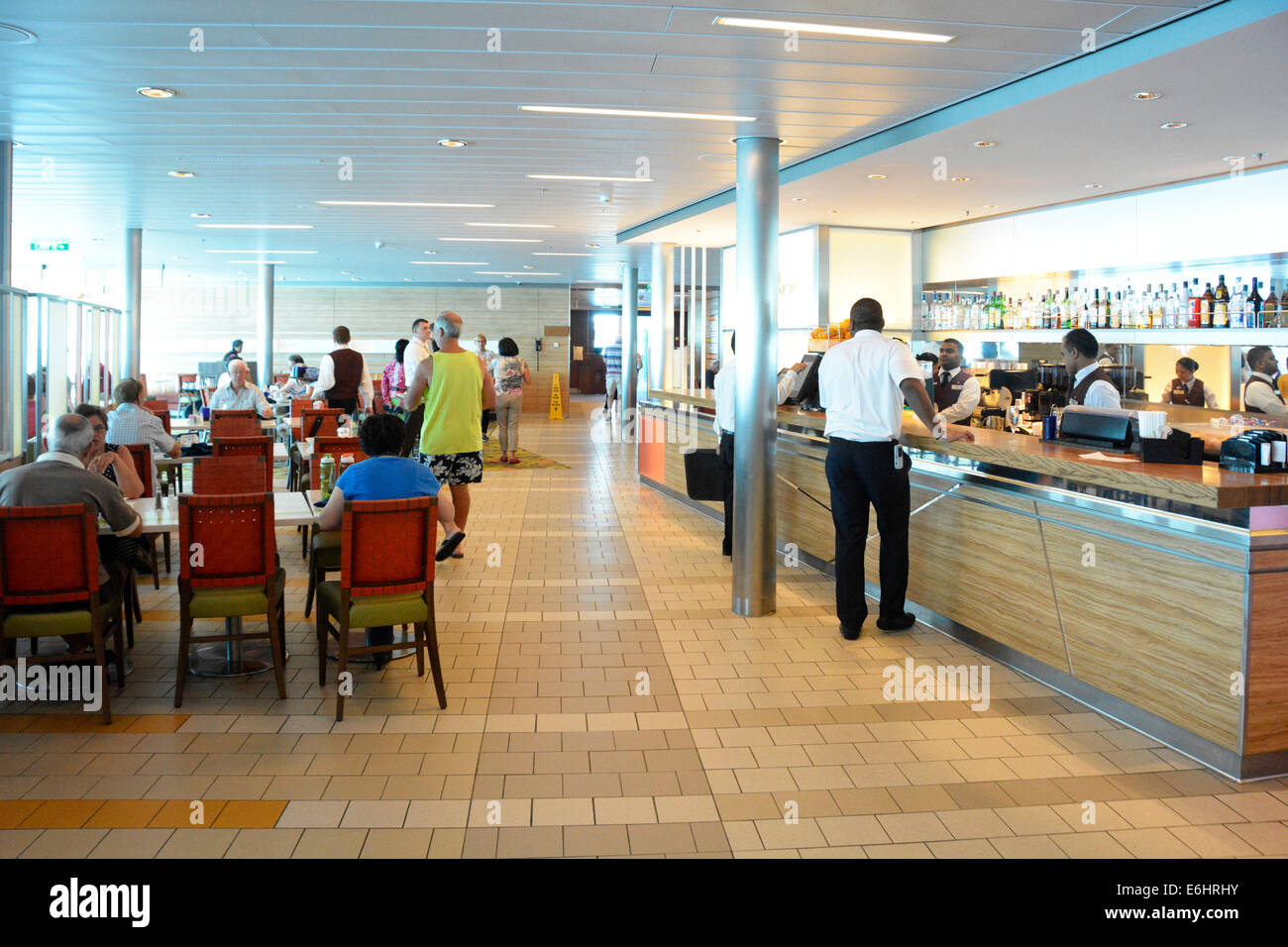 Passengers & staff interior of cruise ship cafeteria deck with breakfast buffet tables with bar counter open aboard a large Mediterranean cruise liner Stock Photo