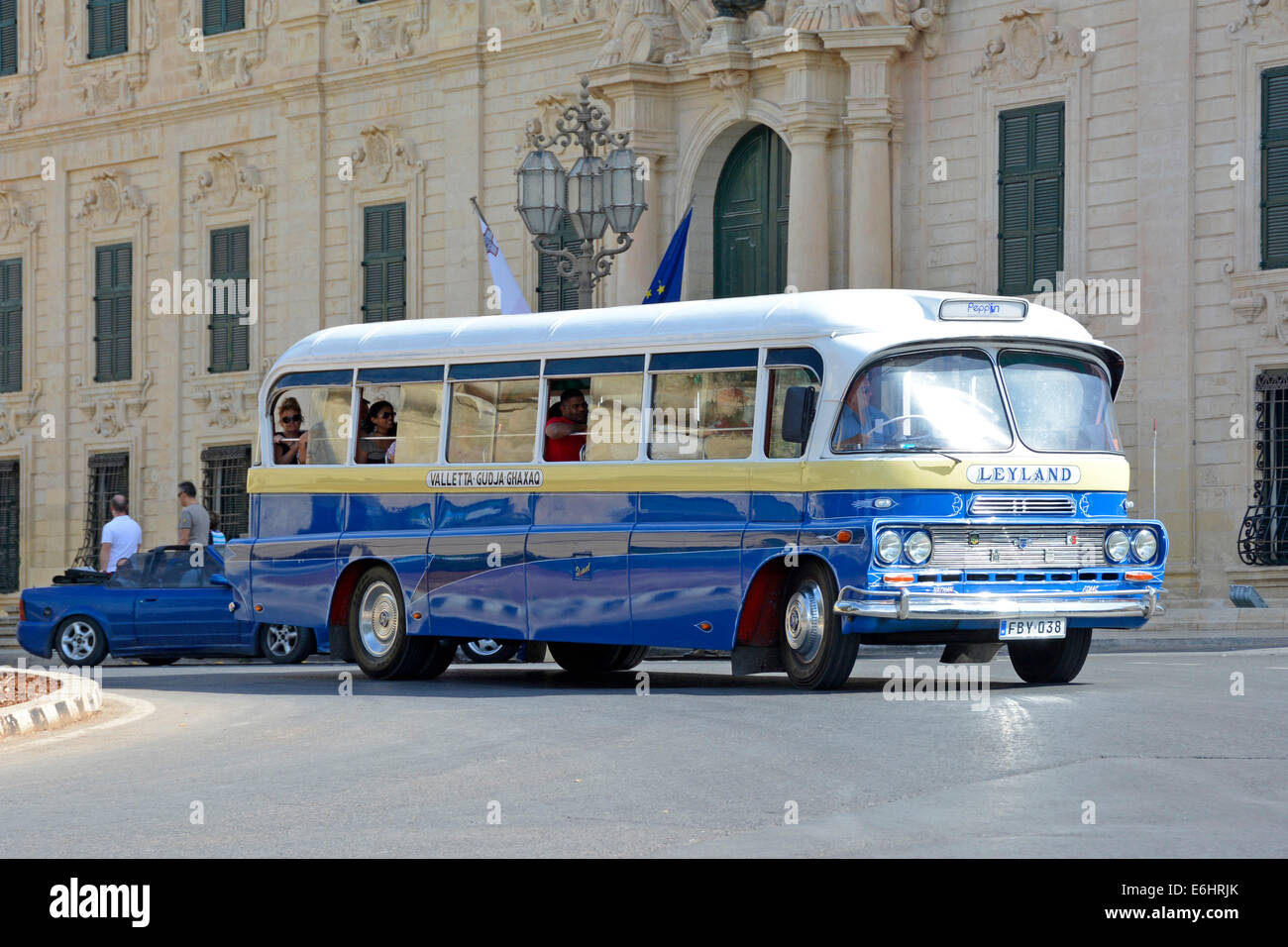 Preserved old blue Leyland bus running a tourist excursion past the office of the Prime Minister in Castille Square Valletta Malta Europe Stock Photo