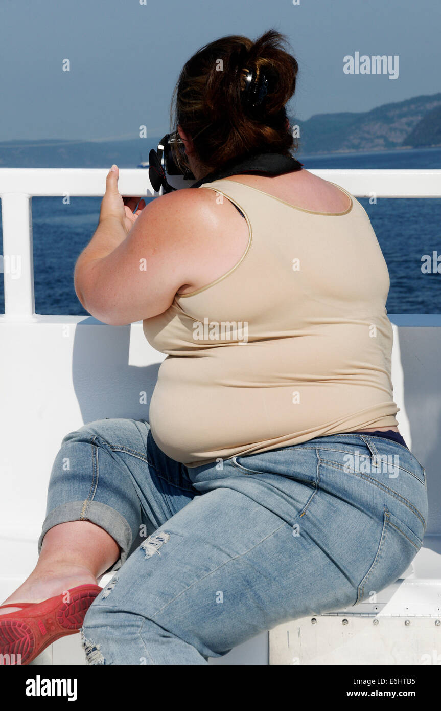 An obese woman sat on a boat Stock Photo