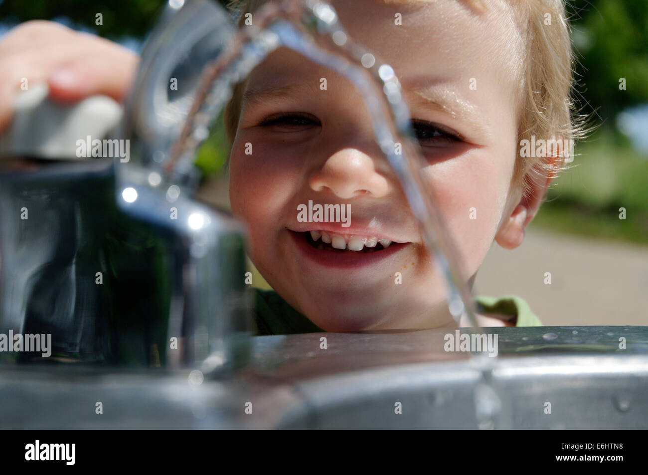 A young boy playing with a drinking water fountain Stock Photo Alamy
