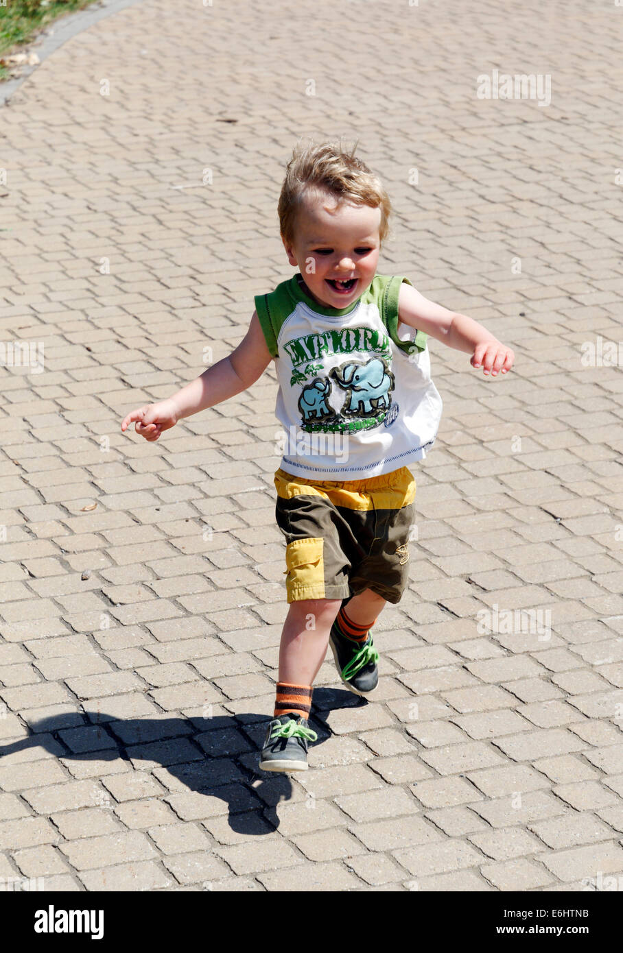 A happy young boy running at full speed Stock Photo