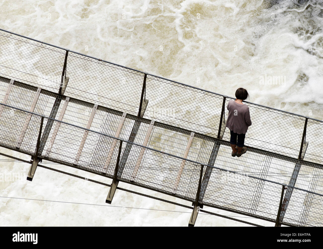 People on a narrow footbridge above turbulent white water at Canyon Ste Anne in Quebebc, Canada Stock Photo