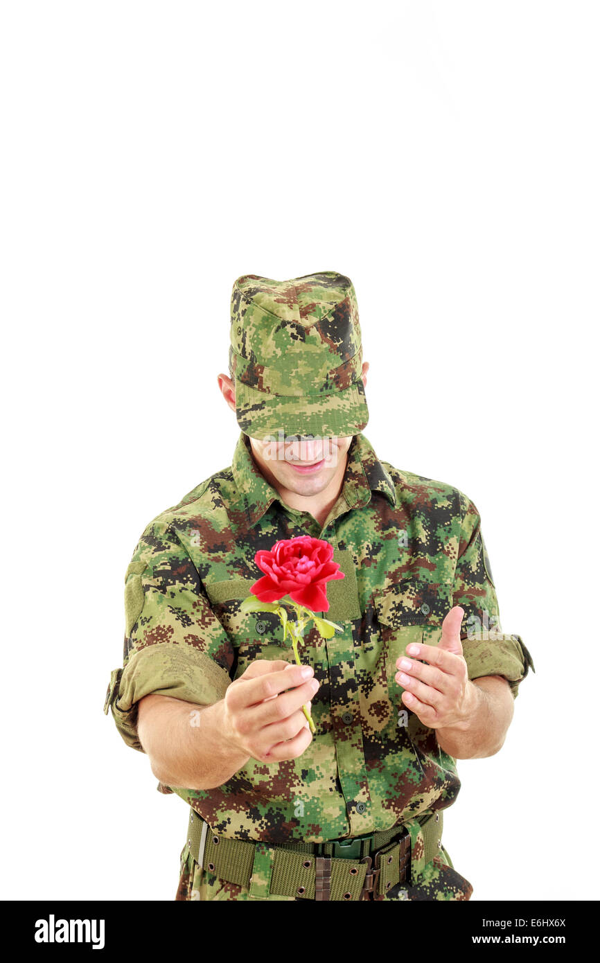 Military officer in army holding flower smiling shy with head bowed, War romantic concept Stock Photo