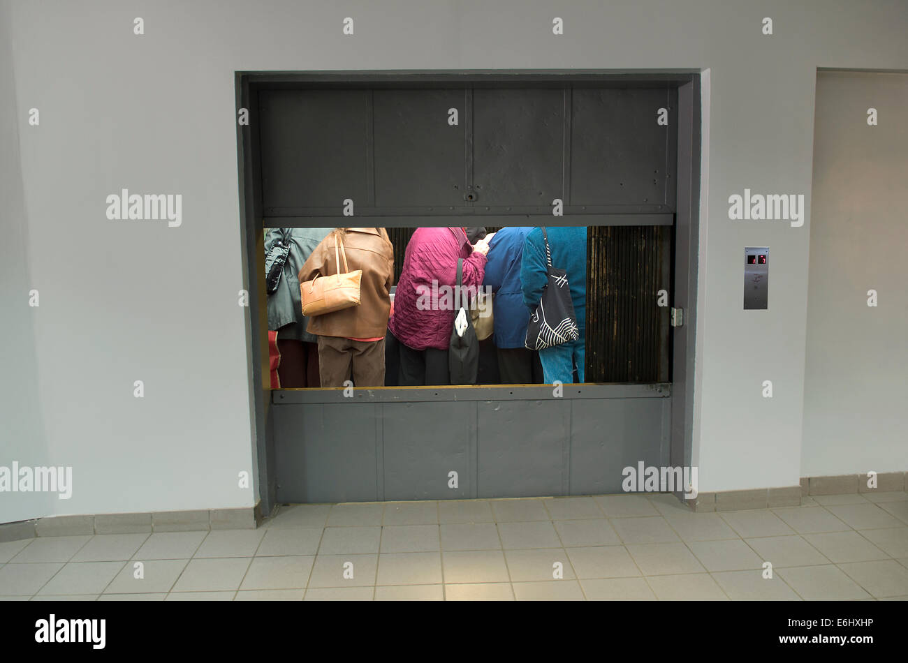 people packed into freight elevator Stock Photo