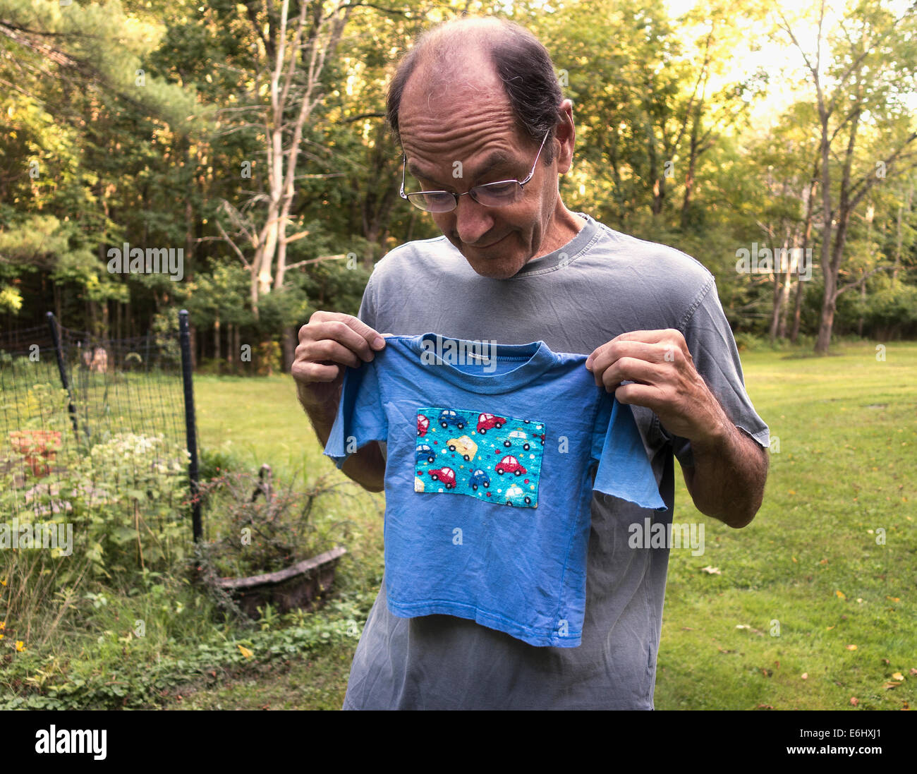senior man on lawn with child's t-shirt Stock Photo