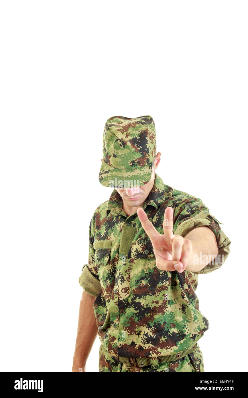 soldier with hidden face in green camouflage uniform and hat standing