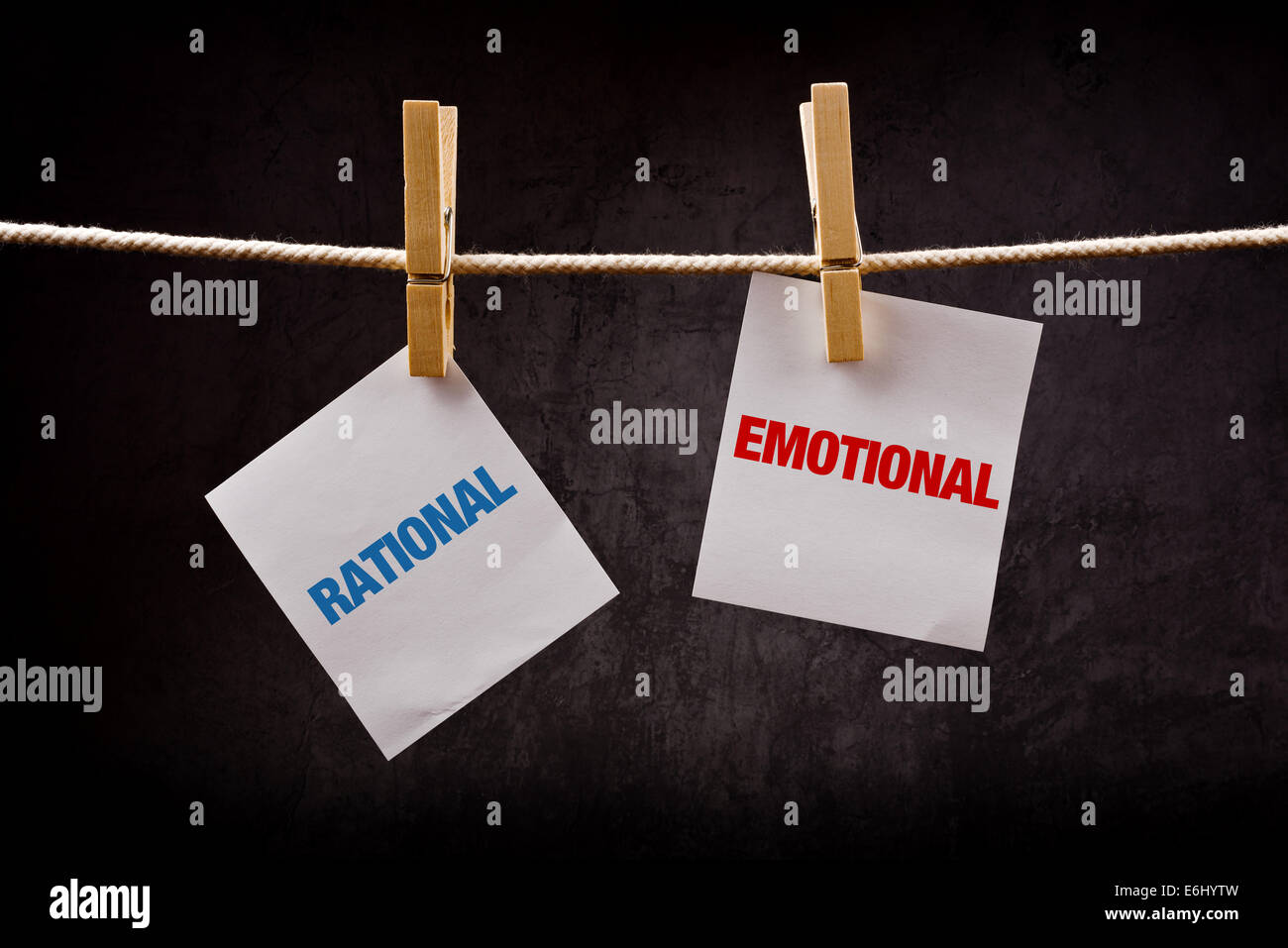 Rational vs Emotional concept. Words printed on note paper and attached to rope with clothes pins. Stock Photo