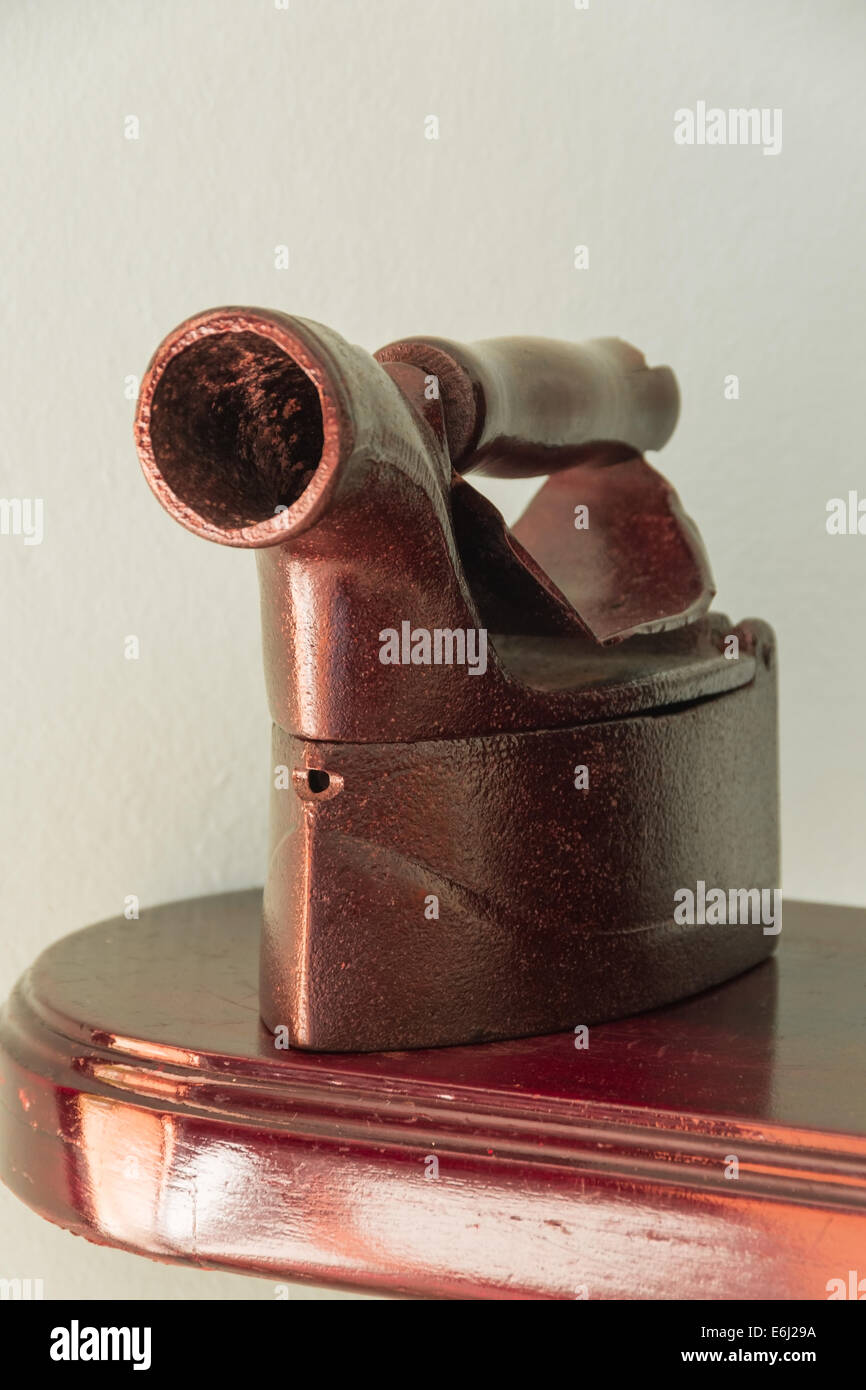 Old charcoal clothing iron on a wood board, vertical composition Stock