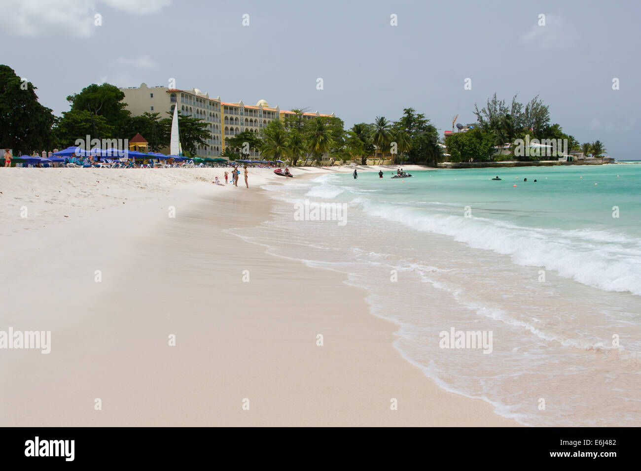 View of Dover Beach Barbados with sea and parasols, hotels in the background Stock Photo