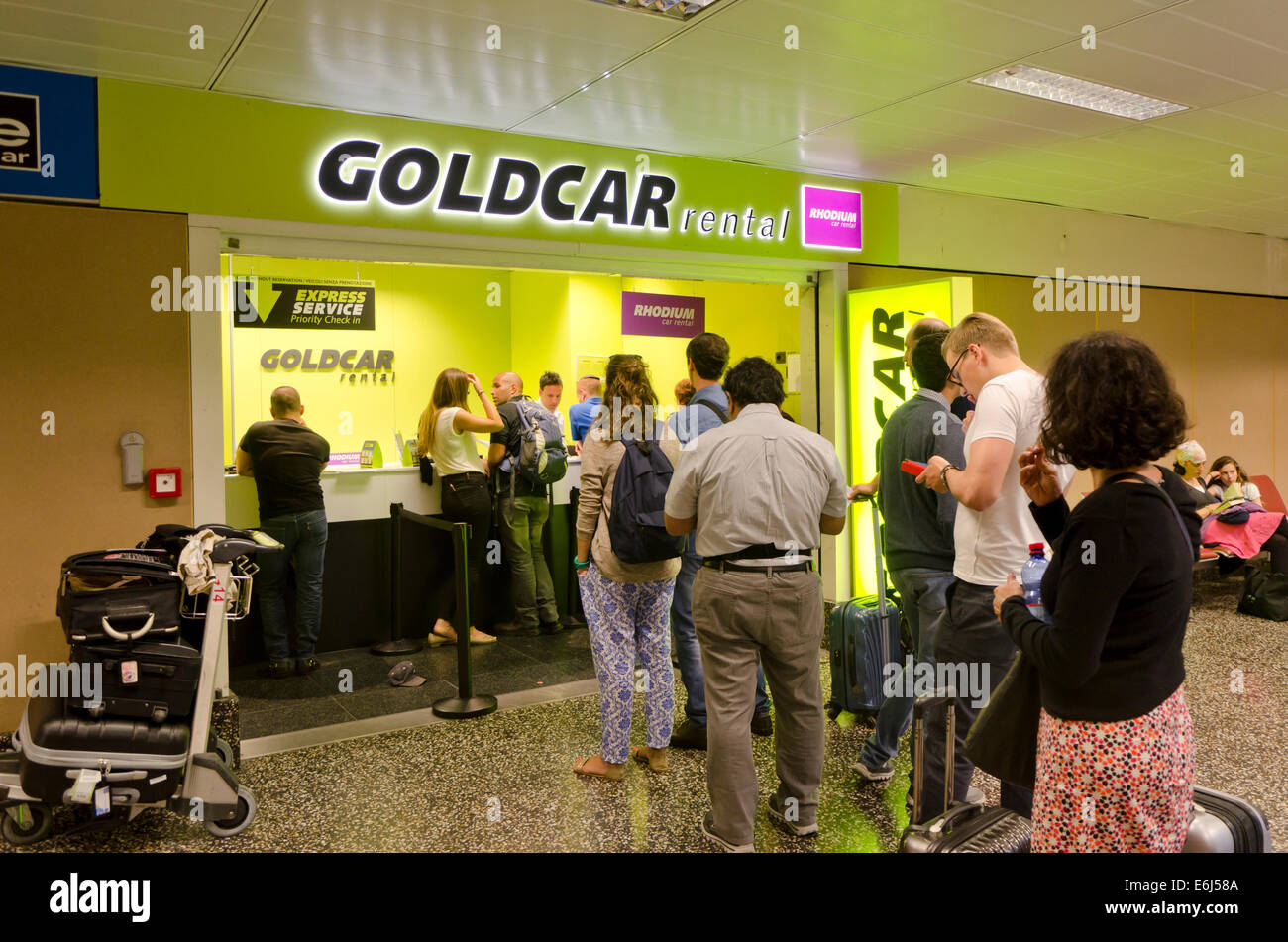 People cuing at Car rental company Goldcar at the airport of Milan, Malpensa. Italy Stock Photo