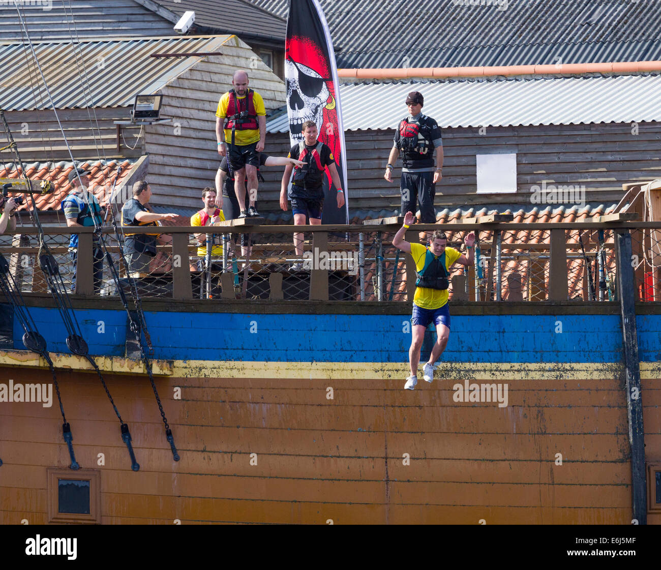 Stockton on Tees, UK. 24th August, 2014. Competitors walking the plank on HMS Endeavour replica  at the 2014 Stockton River Rat Race, a 10km run with land and water obstacles along the banks of the river Tees. Credit:  ALANDAWSONPHOTOGRAPHY/Alamy Live News Stock Photo