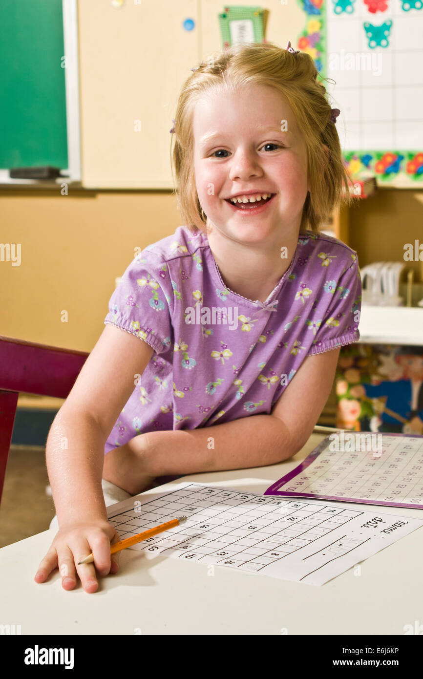 Caucasian Happily Smiling 5 year old students holding pencil paper looking at camera, eye contact smile smiles at table United States  © Myrleen Pearson Stock Photo