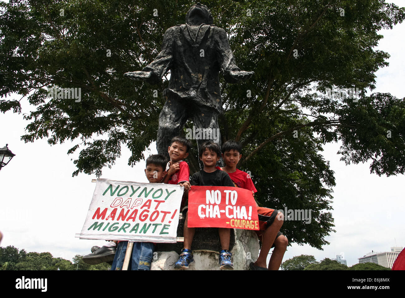 Manila, Philippines. 25th Aug, 2014. Kids sitting at the bottom of the statue of San Lorenzo Ruiz at the Quirino Grandstand poses with posters against Charter Change and Aquino's accountability. Dubbed as the People's Initiative, protesters flocked to the Quirino Grandstand to sign a petition that stops any Charter Change that could extend the term of the president. They are also calling for the abolishment of the Pork Barrel of politicians. Credit:  J Gerard Seguia/Pacific Press/Alamy Live News Stock Photo