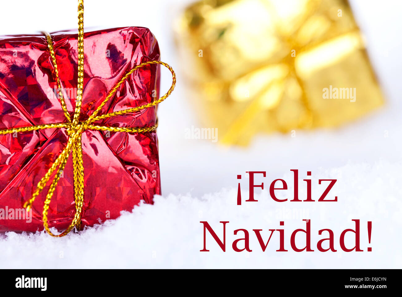 Christmas Gifts in the Snow with the Spanish Christmas Greetings Feliz Navidad which means Merry Christmas Stock Photo