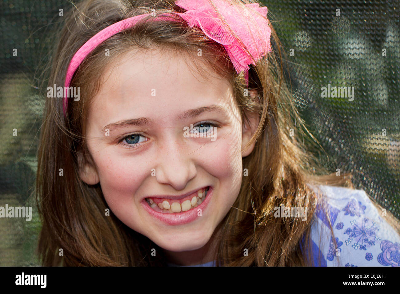 Smiling girl with pink bow Alice band in her hair Stock Photo