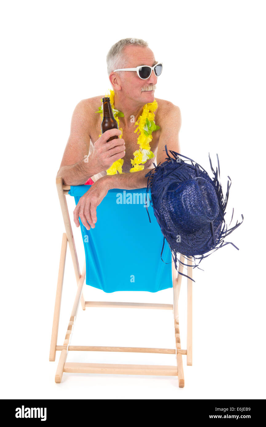 Retired man on vacation sitting in beach chair drinking beer Stock