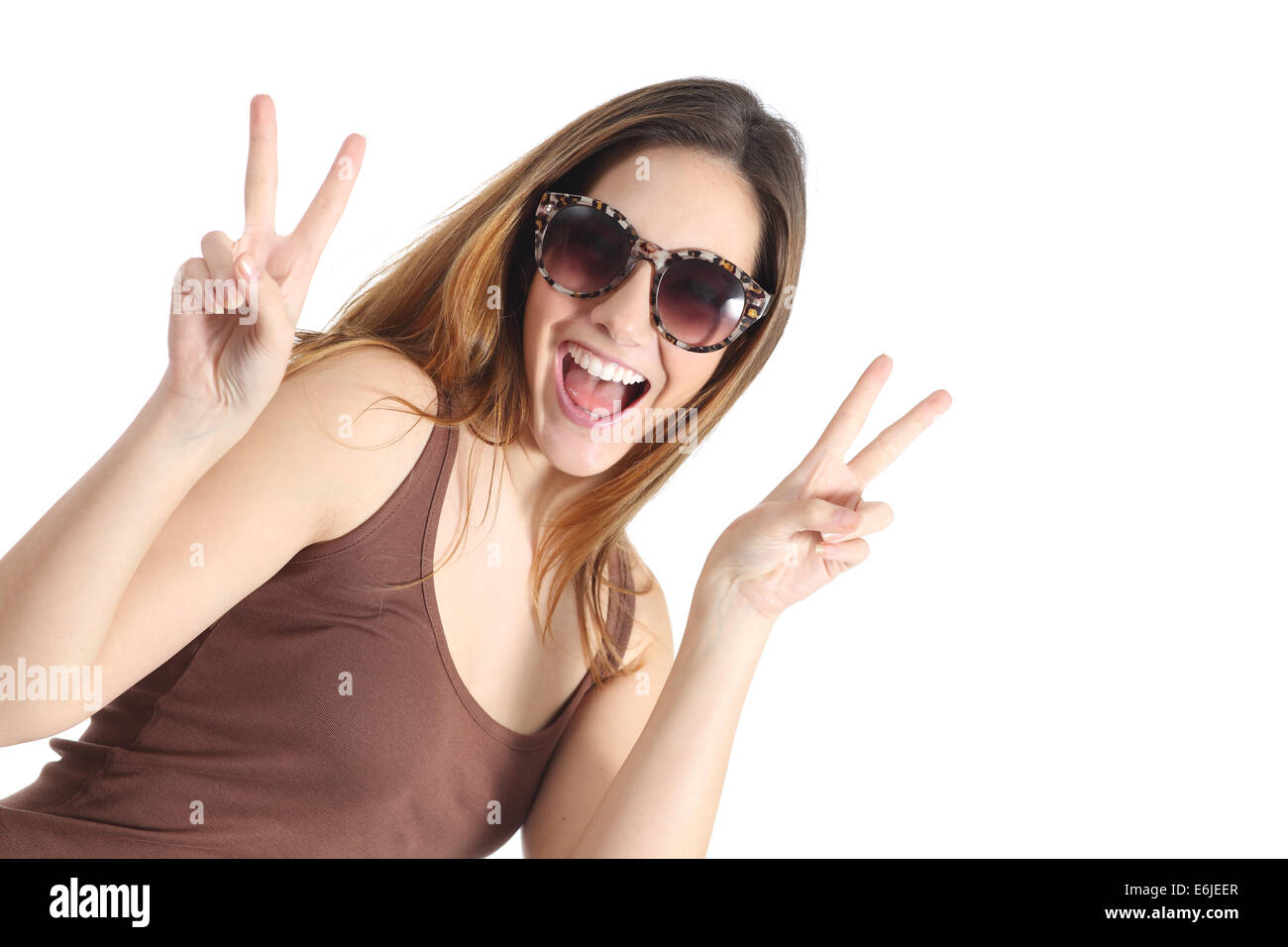 Funny casual teenager girl wearing fashion sunglasses gesturing victory isolated on a white background Stock Photo