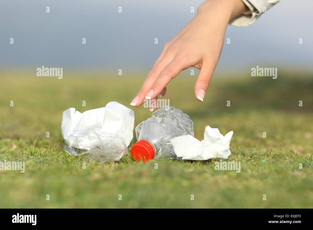 Woman hand collecting garbage of the grass in the mountain with copy space Stock Photo