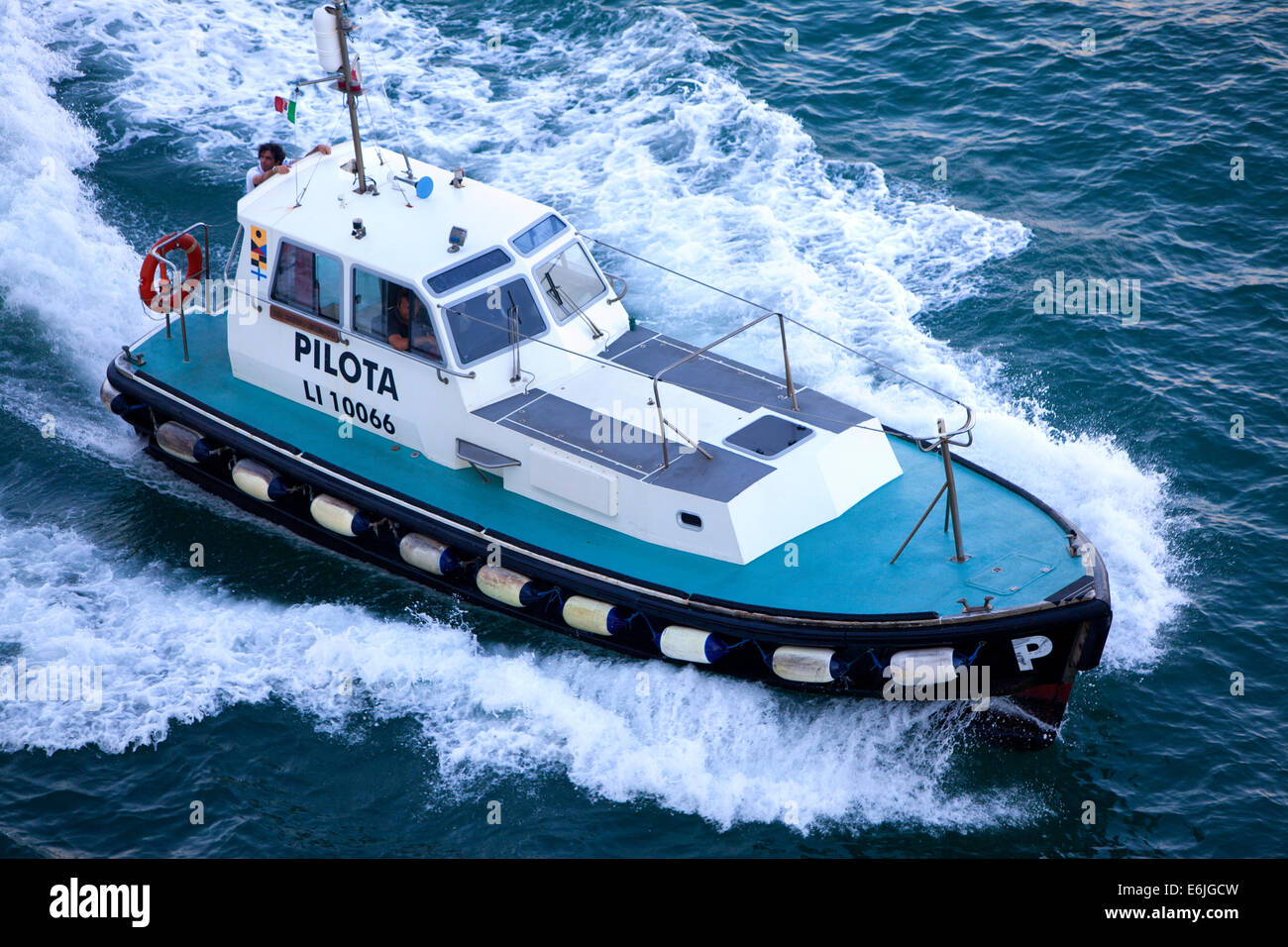 Pilot boat transporting the pilots between land and the outbound cruise ship Stock Photo
