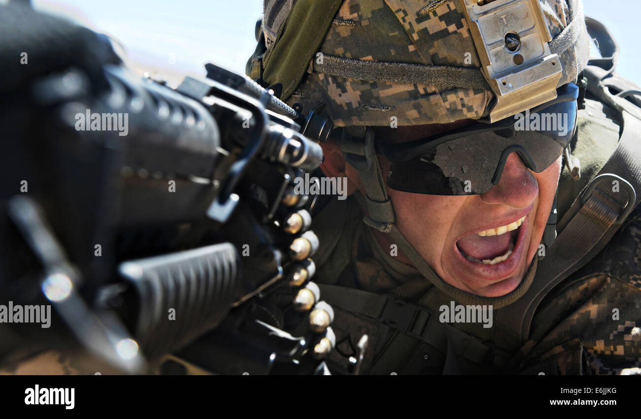 US Army soldier yells for cover fire in the midst of a simulated enemy attack during Decisive Action Rotation at the National Training Center August 14, 2014 in Fort Irwin, CA. Stock Photo