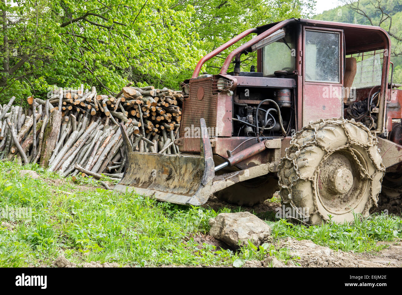 Old bulldozer and wooden bales in a forest Stock Photo