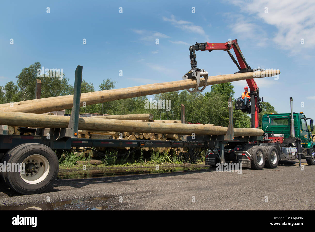 Flat, or open bed truck fitted with knuckle boom for moving telephone poles.  Anastasio Trucking Group. Stock Photo