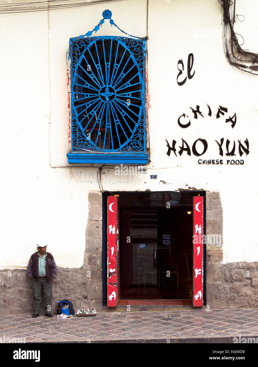 Local man standing near a chinese restaurant - Cusco, Peru Stock Photo
