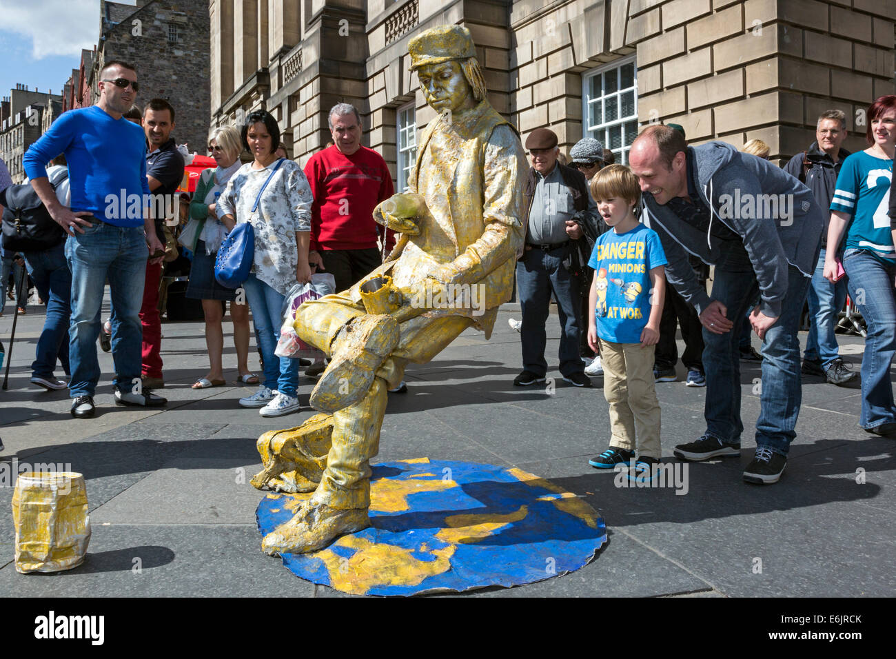 Fergus Beedie, aged 6, from Bishopbriggs near Glasgow is fascinated by the street statue appearing to defy gravity Stock Photo