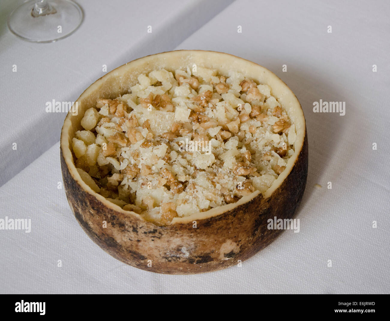Hollowed out Parmesan wheel serving as a pot. Italian cheese served. Italy. Stock Photo