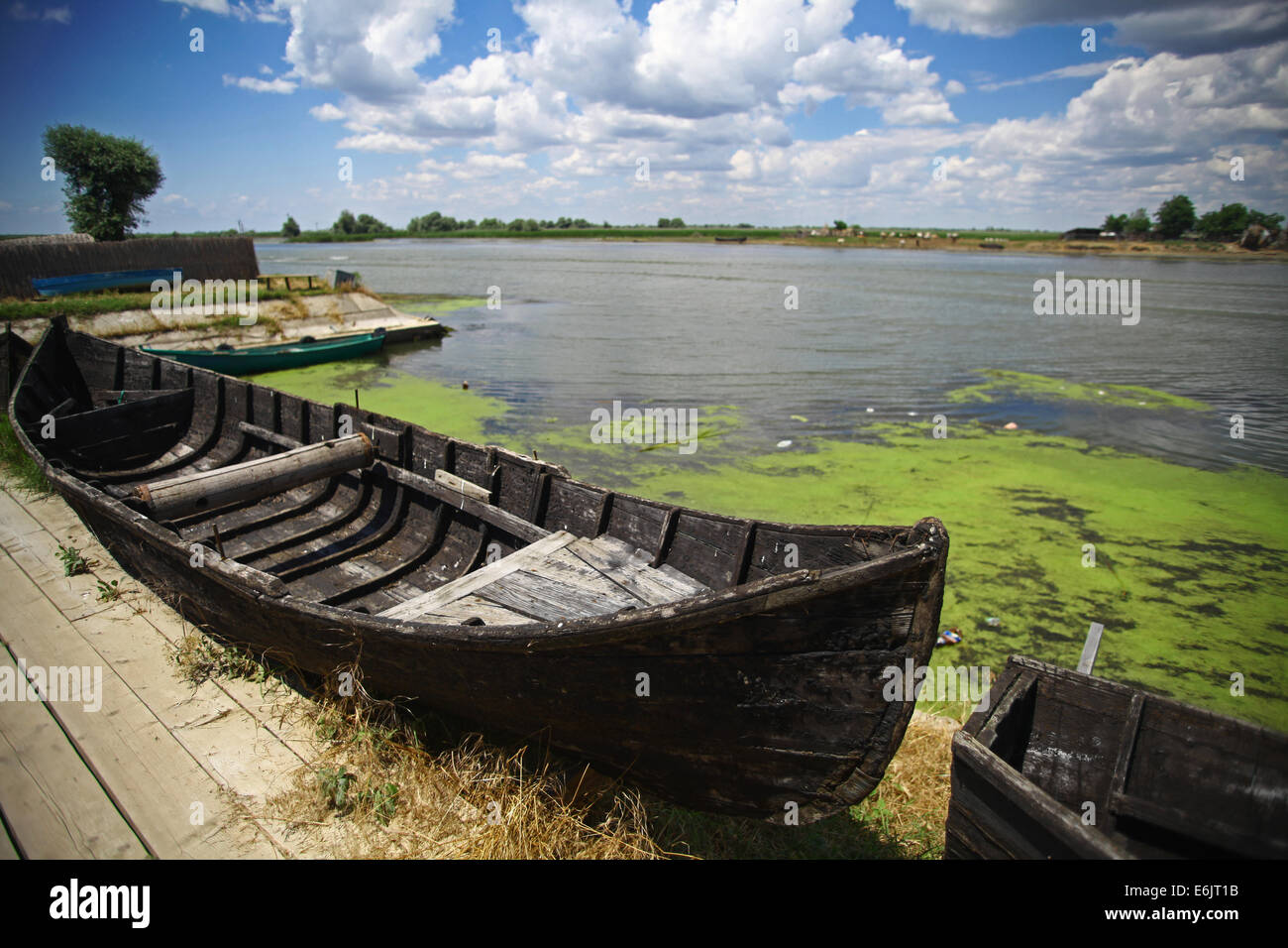 Color picture of a wooden boat on a river bank Stock Photo - Alamy