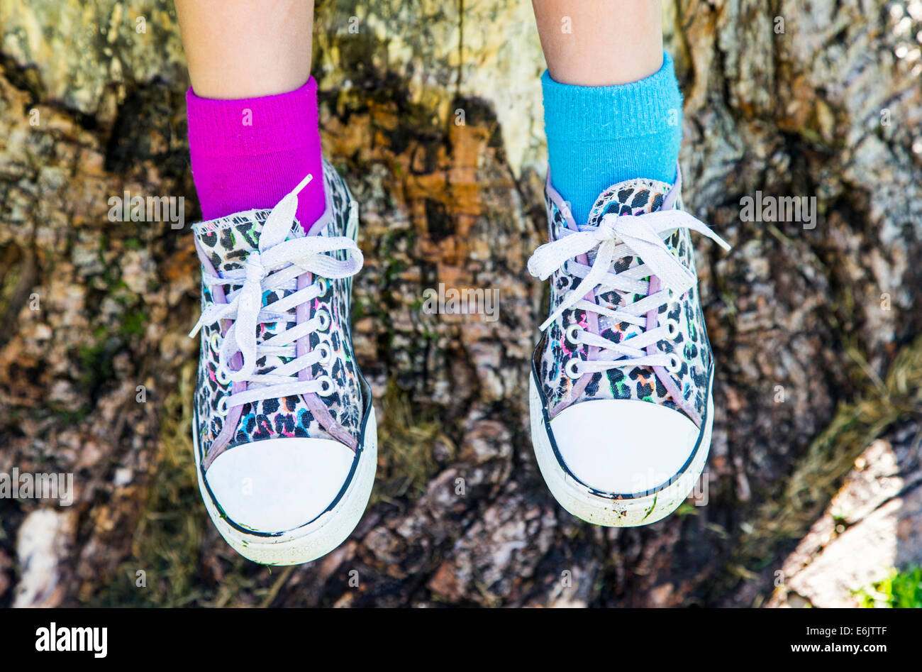 Photograph of seven year old girl's colorful sneakers and two different colors of socks Stock Photo