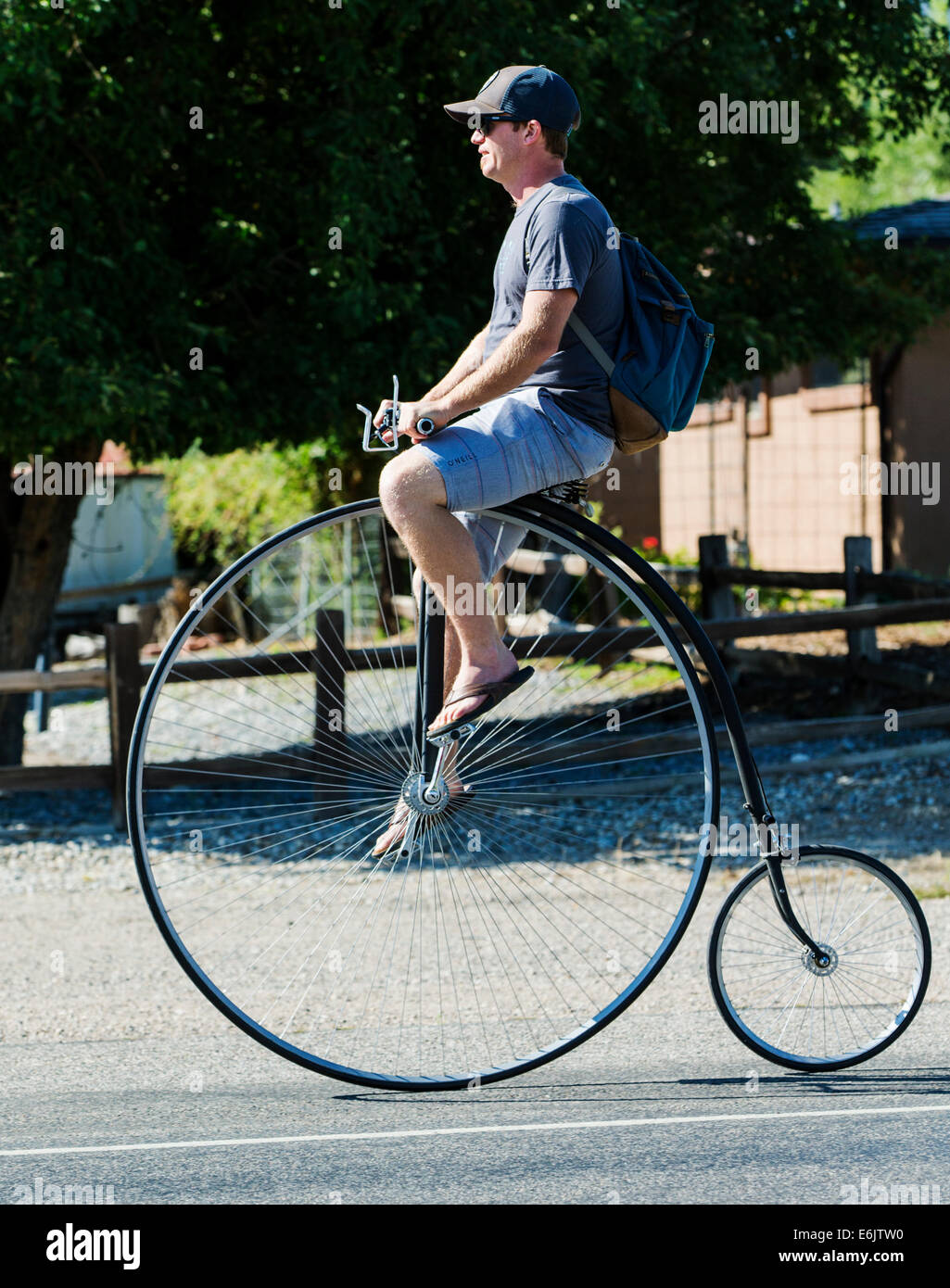 Man riding a penny-farthing, high wheel, high wheeler, or ordinary bicycle Stock Photo