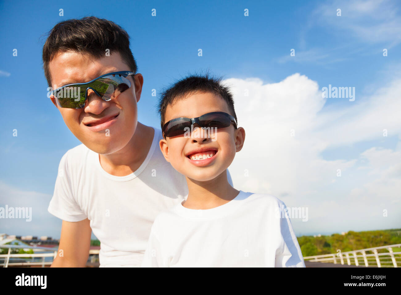 father and son making a grimace together in the park Stock Photo