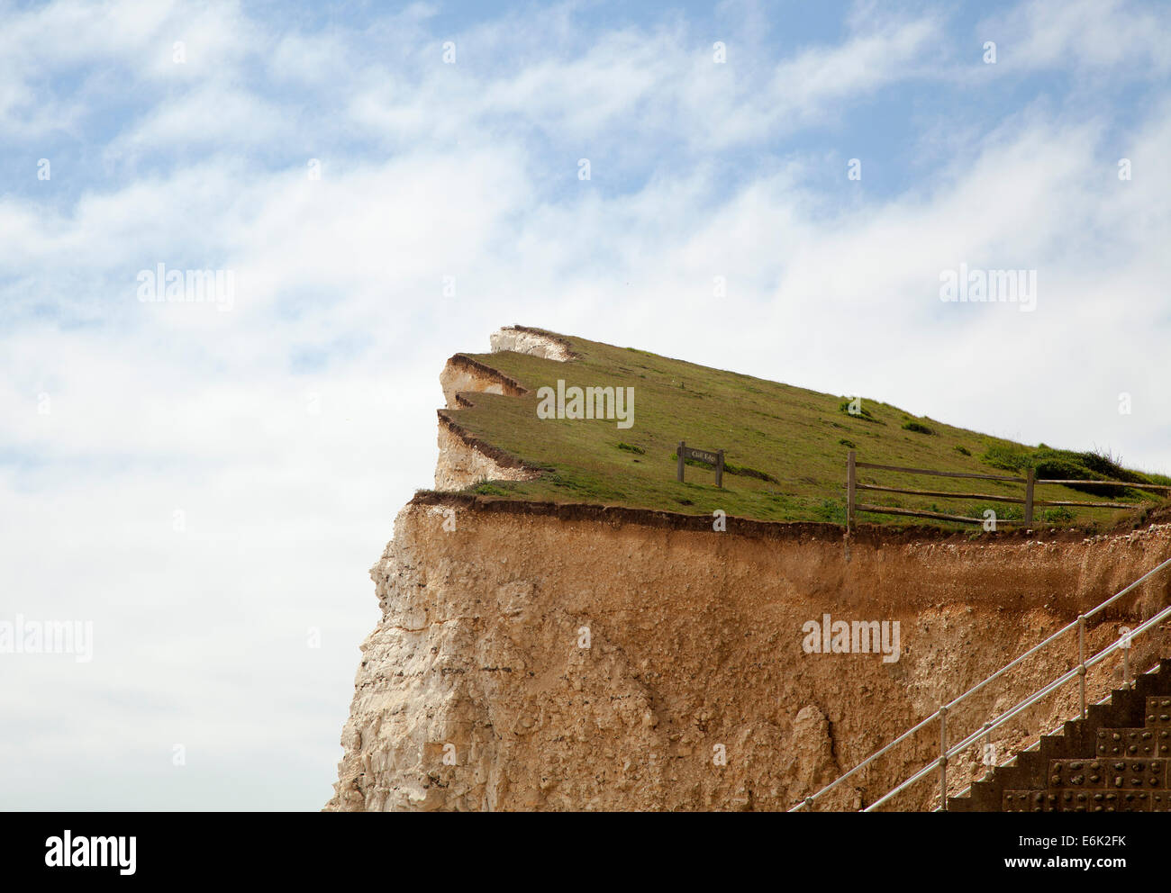 A chalk cliff edge against blue sky and clouds Stock Photo