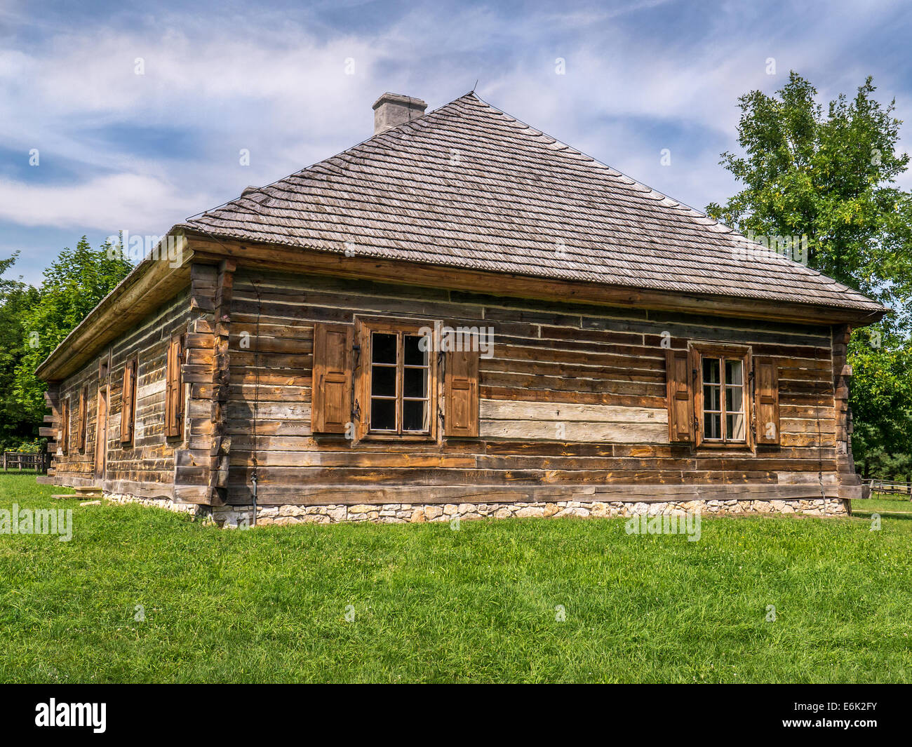 Old style wooden cottage with window shutters Stock Photo