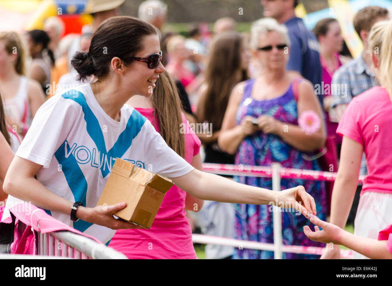 Woman handing out medals at Race-for-Live event, UK 2014 Stock Photo
