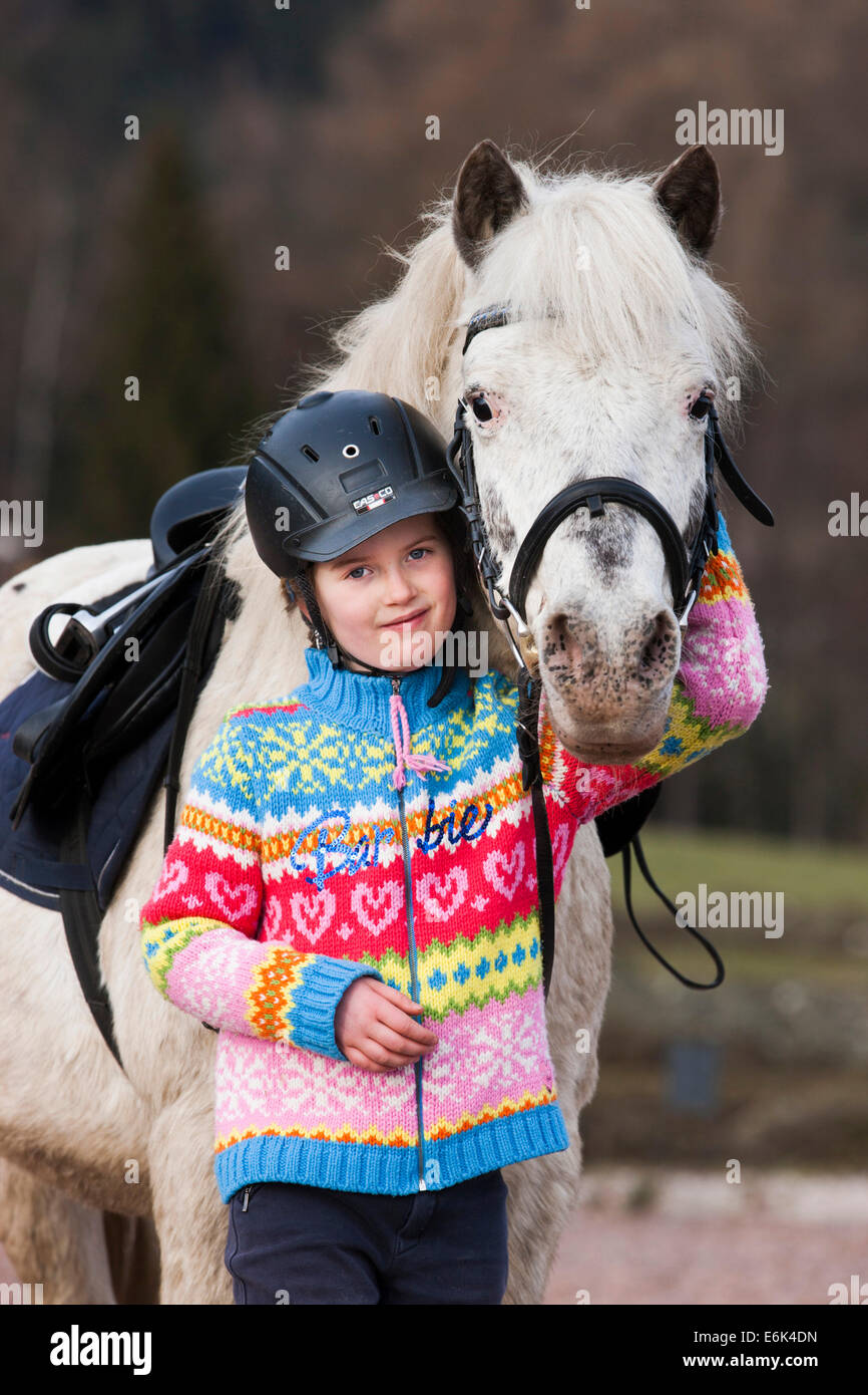 Girl standing beside a pony, gray, Tyrol, Austria Stock Photo